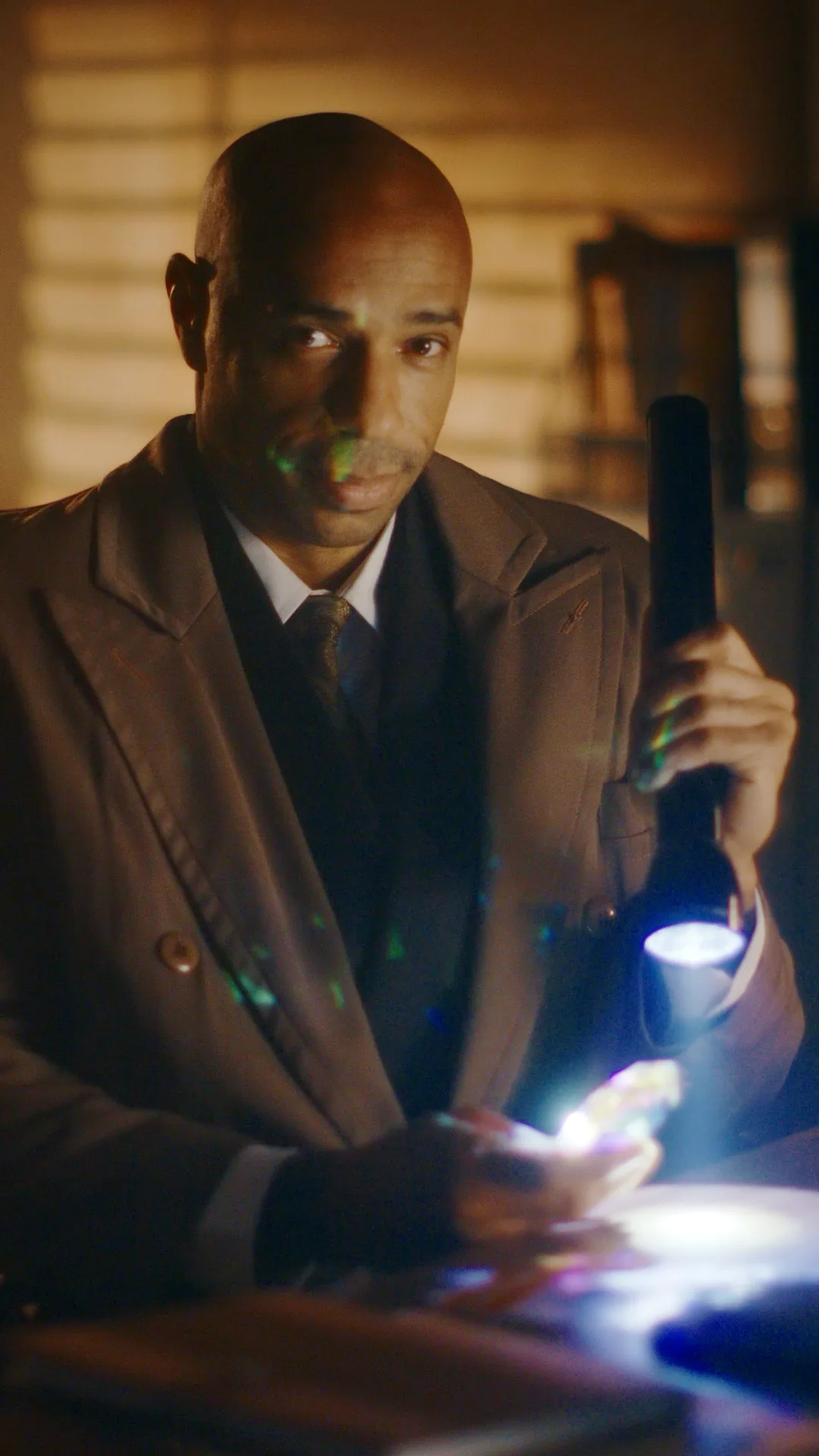 Thierry Henry as a detective holding a flashlight