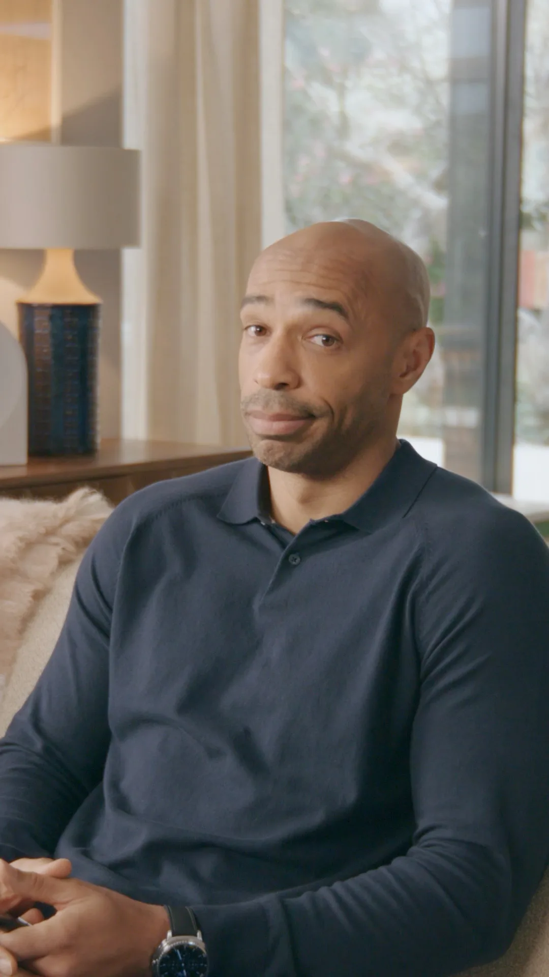 Thierry Henry watching TV from his sofa