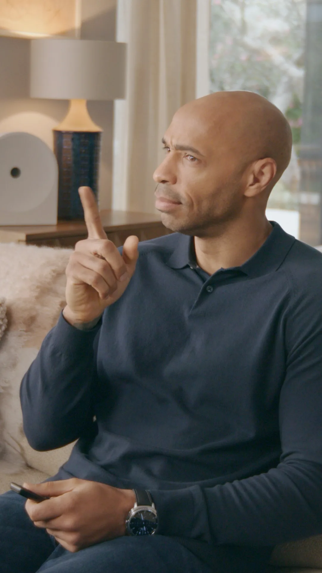 Thierry Henry pointing while reacting to the TV